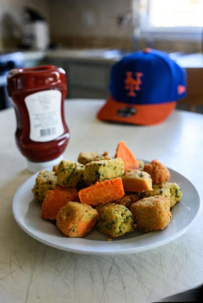 a plate of golden veggie nuggets on a scratched Queens apartment kitchen table. a plate of golden veggie nuggets on a scratched Queens apartment kitchen table.