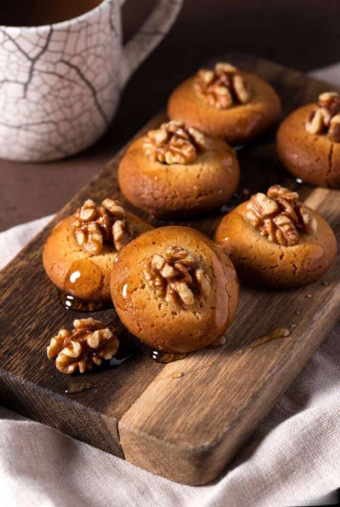 freshly syrup-soaked melomakarona on a rustic wooden tray. freshly syrup-soaked melomakarona on a rustic wooden tray.