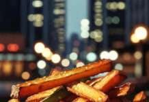KFC Style Veg Strips Recipe: So Good They’ll Make You Forget Chicken crispy golden veg strips piled in a rustic metal basket with NYC night lights in the background.